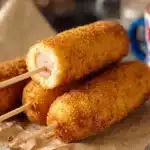 Chien de maïs savoureux servi avec des accompagnements colorés.