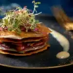 Mille-feuilles de magret aux cèpes, crousti-fondants sur une assiette élégante